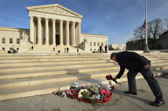 James Peck of Springfield, Virginia, lays flowers down at a makeshift memorial for Supreme Court Justice Antonin Scalia on Sunday February 14, 2016, in Washington, D.C. Photo by Matt McClain/ The Washington Post via Getty Images