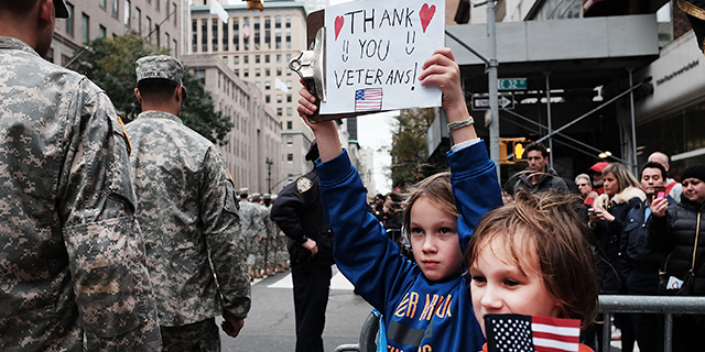 Gavin Kinney, left, and his brother Rigel hold up a sign at the New York City Veterans Day Parade on Nov. 11, 2015. (Spencer Platt/Getty Images)