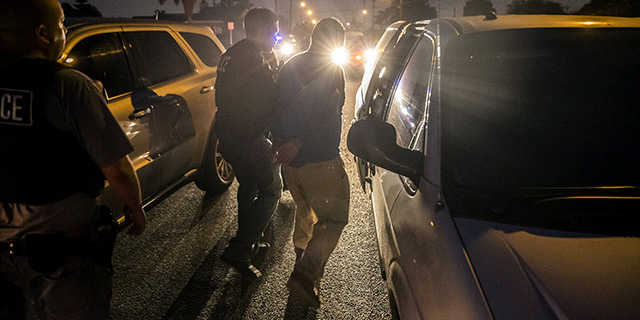 Immigration and Customs Enforcement agents take a man into custody in Downey, California, in April 2017. (Brian van der Brug/Los Angeles Times via Getty Images)