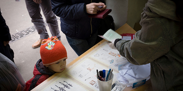 A refugee child at the Berlin administration facility for health and social welfare waits to receive toiletries from volunteers. (Colin McPherson/Corbis via Getty Images)
