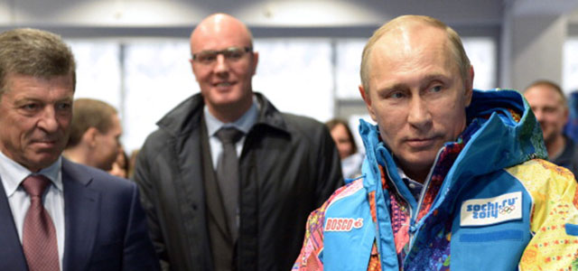 Russian President Vladimir Putin (R) tries an Olympic volunteers uniform, visiting an equipment centre in Sochi on January 4, 2014. Credit: ALEXEY NIKOLSKY/AFP/Getty Images